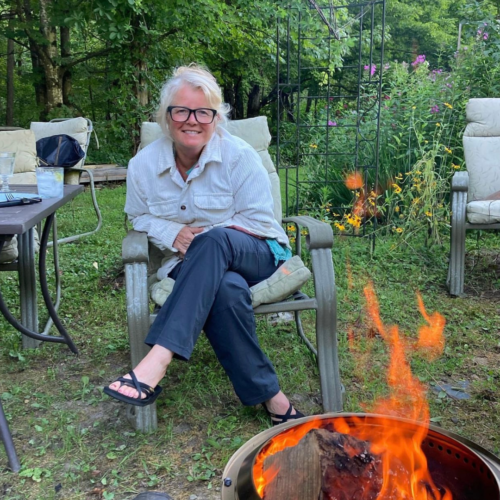 Melanie Keiser sitting in front of a fire pit in her back yard